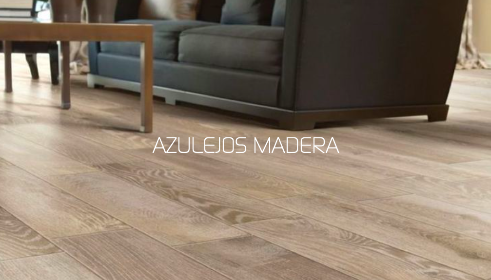 Suelo de madera claro con un sofá oscuro y una mesa en el espacio habitable.