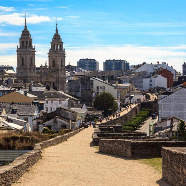 Vista de un pueblo con iglesias de torres y casas de techos de tejas en Caceres