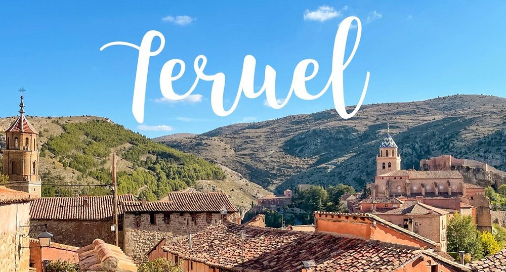 Vista panorámica de Teruel con edificios históricos y montañas al fondo.