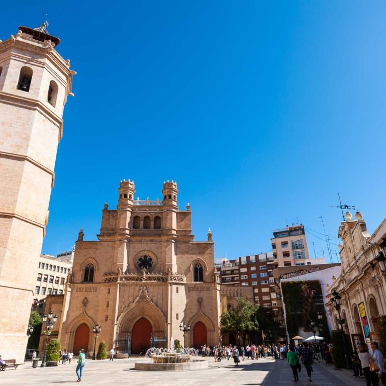 Vista panorámica de una plaza con una catedral y edificios históricos bajo un cielo azul.