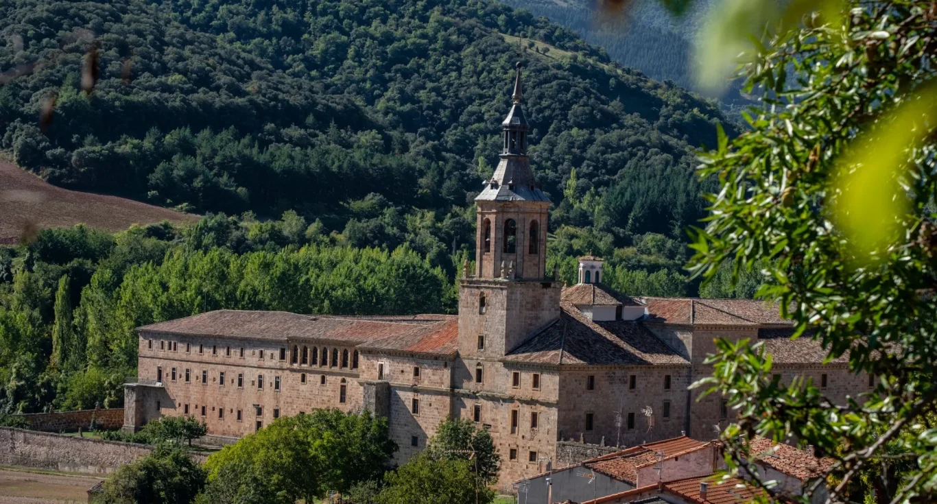 Monasterio rodeado de naturaleza, con torre y vistas a las montañas de LA RIOJA