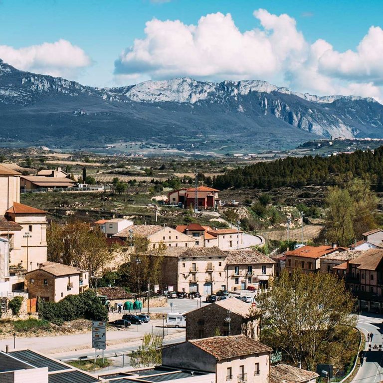 Vista panorámica de un pueblo rodeado de montañas y un cielo despejado.